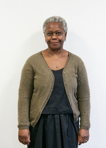 Professor Dame Donna Kinnair, a Black woman with short grey hair, wearing a green cardigan over a black top and skirt